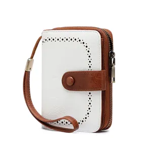 Detail of white lychee leather wallet with brown trim and vintage cutout patterns