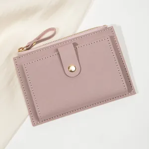 Vue détaillée du petit portefeuille rose avec texture cuir, zip et rabat à pression