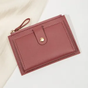 Détails du cuir bordeaux avec finitions dorées et coutures précises du portefeuille