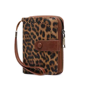 Detail of RFID blocking leopard print wallet featuring zip closure and brown wristlet strap