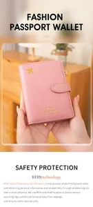 Pink RFID travel wallet with airplane logo being held by hands in a warm home setting