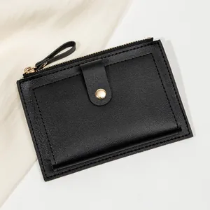 Détail du portefeuille en cuir noir avec fermeture éclair dorée et coutures fines