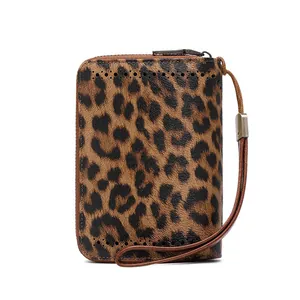 Detail view of leopard print leather wallet featuring secure zipper and wrist strap