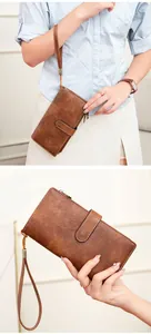 Detail view of a vintage dark brown leather long wallet with wristlet and snap closure