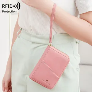 Pink RFID blocking passport wallet in textured leather with wristlet strap for travel