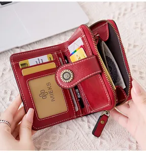 Détail du portefeuille rouge ajouré montrant les fentes pour cartes et le zip