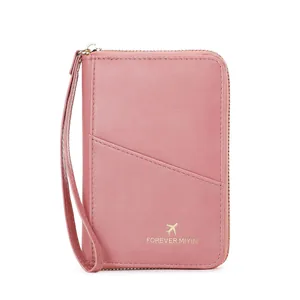 Pink RFID blocking passport wallet with zipper and wristlet for travel organization