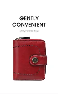 Détail du portefeuille en cuir rouge avec motif ajouré, boucle rétro et fermeture éclair