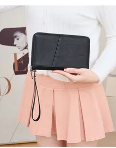 Détail macro du protège-passeport RFID en cuir noir avec texture litchi et dragonne
