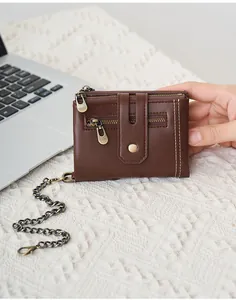 Detail van vintage bruine RFID-portemonnee met dubbel stiksel en antidiefstalketting