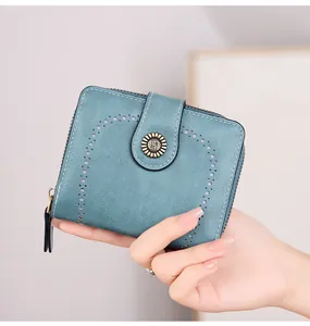 Gros plan du portefeuille court vintage pour femme en bleu cyan avec découpes et bouton