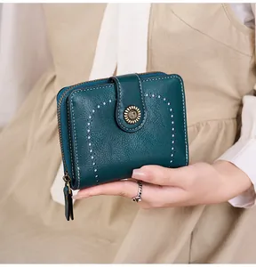 Détail d'un portefeuille vintage en cuir texturé avec boucle métal et surpiqûres
