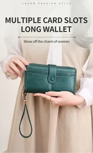 Dettaglio portafoglio lungo verde scuro in pelle con cinturino e zip metallica