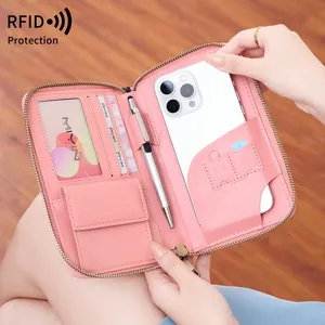 Pink leather RFID passport wallet held by hand showing multi-functional interior storage
