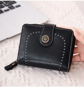 Détail du portefeuille noir avec design ajouré et boucle rétro en métal bronzé