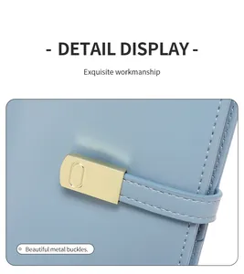 Close-up of light blue leather wallet with fine stitching and gold metal buckle detail
