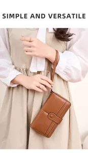 Portafoglio in pelle marrone con fessure per carte e cinturino tenuto da una modella