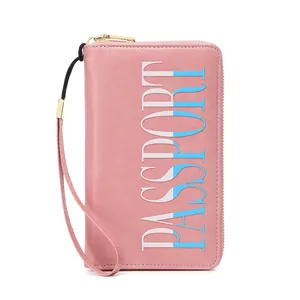 Pink RFID passport holder wallet with vertical logo and secure wristlet strap