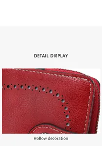 Détail du portefeuille en cuir rouge grainé avec motif ajouré et surpiqûres blanches