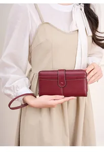 Dettaglio del portafoglio lungo RFID in pelle bordeaux con cinturino da polso