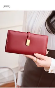 Detailed view of wine red RFID women's long wallet with elegant gold metal clasp