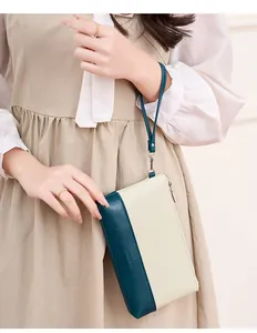 Détail de la pochette bicolore en similicuir haut de gamme avec dragonne et logo de marque