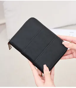 Close-up of hand-held black crazy horse leather RFID passport wallet with zip closure