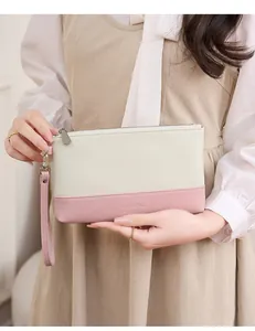 Détail de la texture en cuir PU bicolore et de la dragonne amovible de la pochette chic