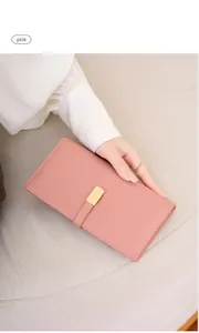 Close-up of pink long slim wallet with golden buckle and fine stitching details