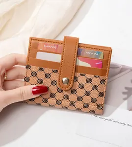 Detail of slim brown bifold wallet showing multiple card slots and snap fastener