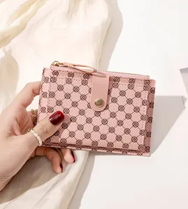 Close-up of pink folding card holder with brown clover pattern and gold buckle details