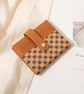 Detail view of a compact brown floral wallet with card slots and a gold snap button