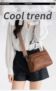 Detail of vintage soft leather bag with geometric patterned wide crossbody strap