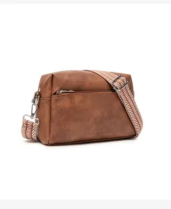 Detail of vintage brown soft leather crossbody bag with geometric woven strap and zipper