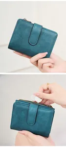 Close-up of vintage blue RFID tri-fold wallet showing cracked leather texture and coin pocket