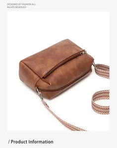 Detail view of vintage brown PU leather bag featuring a black and white geometric wide strap