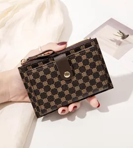 Detail of dark brown leather wallet showing vintage clover print and golden zipper