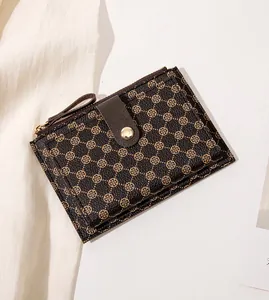 Close-up of retro brown faux leather mini wallet with clover pattern and metal snap button