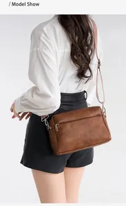 Detailed back view of a vintage brown crossbody bag with textured leather and wide strap