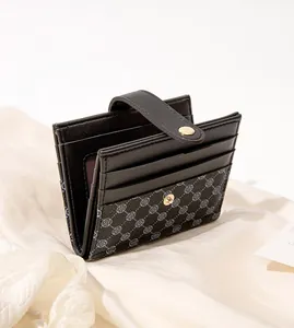 Detail view of the black bifold wallet with clover print card slots and snap closure