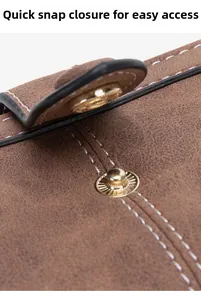 Détail du fermoir à pression sur portefeuille en cuir vintage marron aux coutures blanches