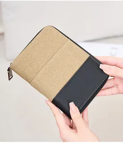 Detail of RFID travel wallet in khaki canvas and black faux leather with metal zipper