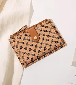 Detailed macro view of the brown lychee grain texture and clover print on the wallet