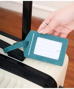 Detail of adjustable PU leather luggage tag with name card on a textured suitcase