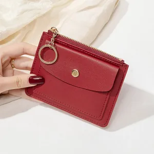 Détail du porte-monnaie en cuir rouge avec motif litchi texturé et porte-clés doré