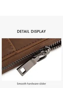 Detail of smooth gunmetal hardware slider on vintage crazy horse leather travel wallet