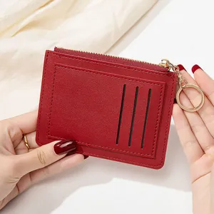 Détail du porte-cartes rouge mince avec texture en cuir PU et porte-clés doré métallique