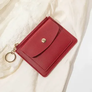 Vue détaillée du porte-cartes rouge grainé avec bouton pression doré et fermeture éclair
