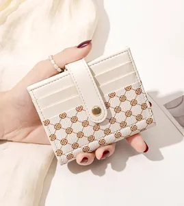 Detailed view of women's folding card wallet with clover monogram and metal snap button