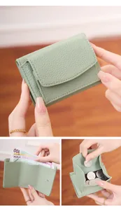 Detail view of mint green pebble grain wallet featuring tri-fold card slots and coin pocket